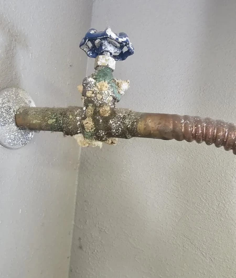 Heavy mineral scale and green corrosion on a copper hose bib and shut-off valve at a Mesa home