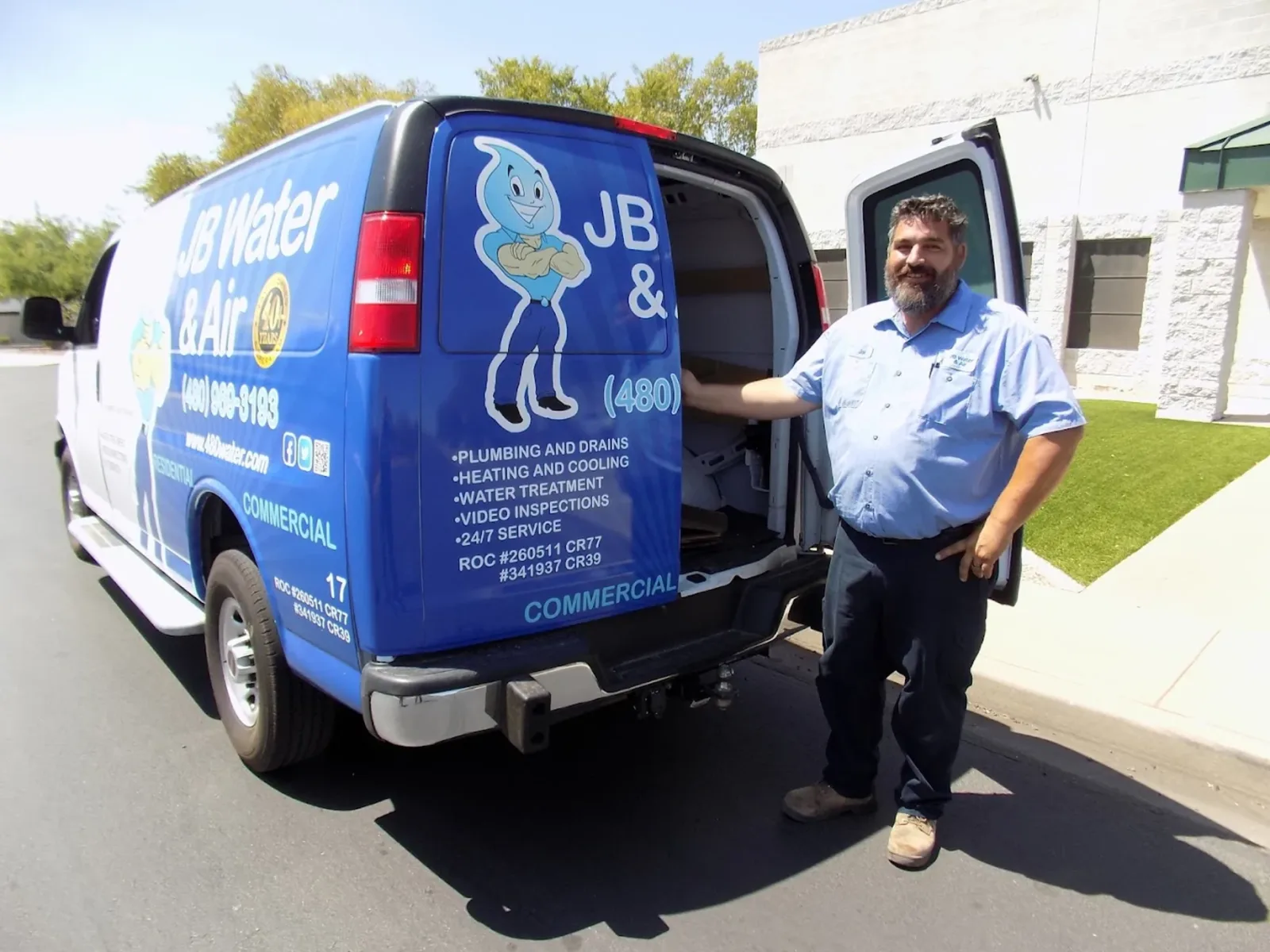 A JB Water & Air technician beside a branded JB Water & Air service van in Mesa, Arizona