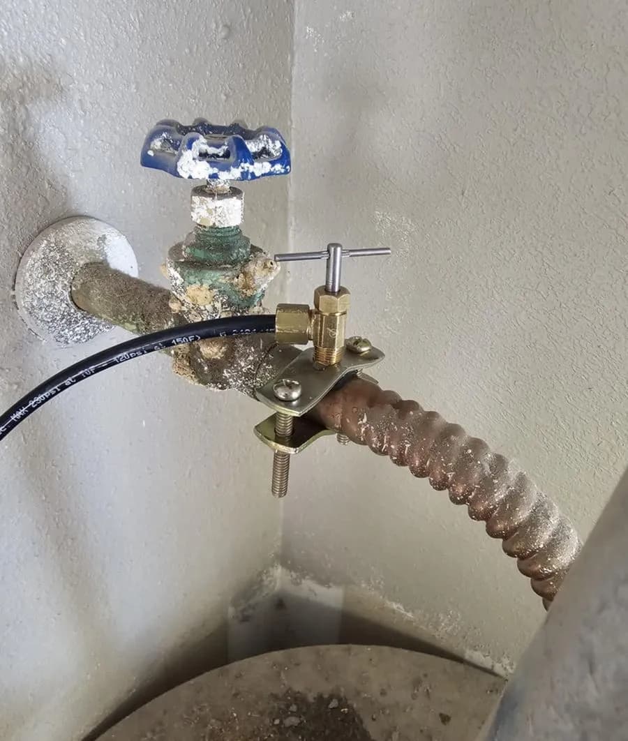 A drain hose connected to a water heater drain valve during a maintenance flush